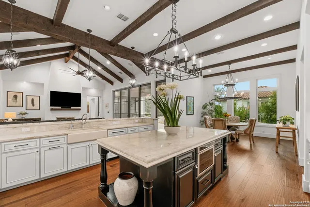 a kitchen with a table chairs stove and wooden floor