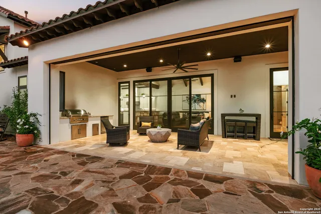 a living room with furniture ceiling fan and a large window