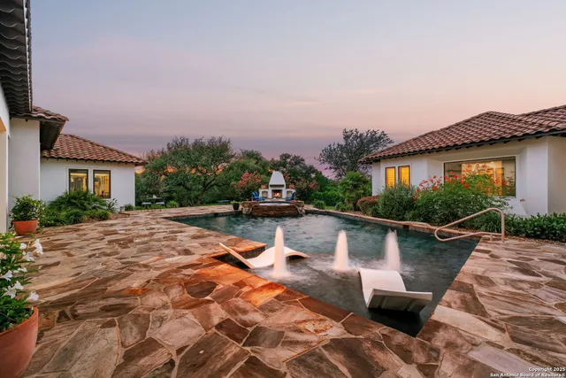 a view of house with swimming pool and sitting area