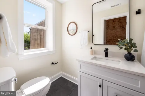 a bathroom with a toilet a sink and a mirror