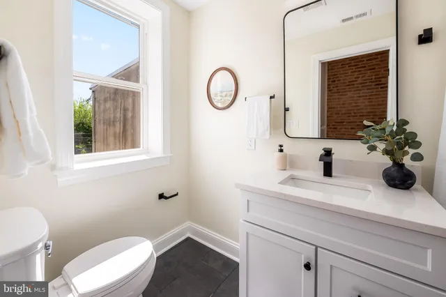 a bathroom with a toilet a sink and a mirror