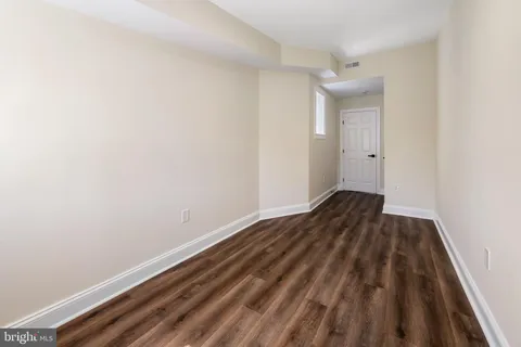 a view of a room with wooden floor and bench