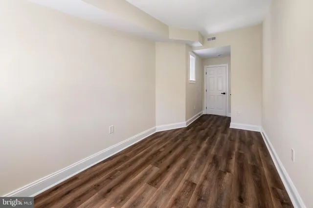 a view of a room with wooden floor and bench