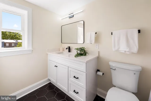 a bathroom with a toilet sink and mirror