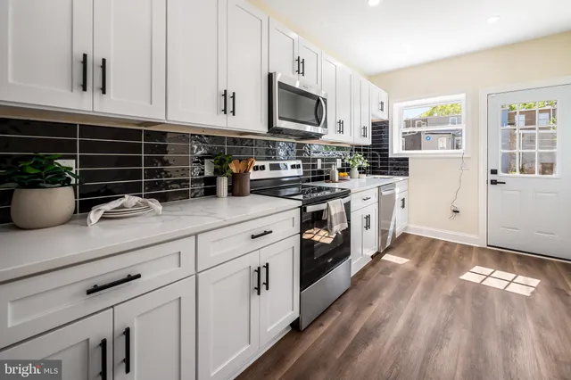 a kitchen with appliances a sink and cabinets