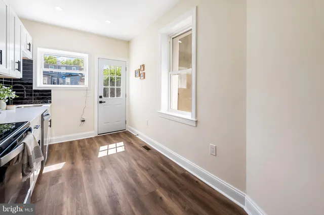 a view of a kitchen with wooden floor and electronic appliances