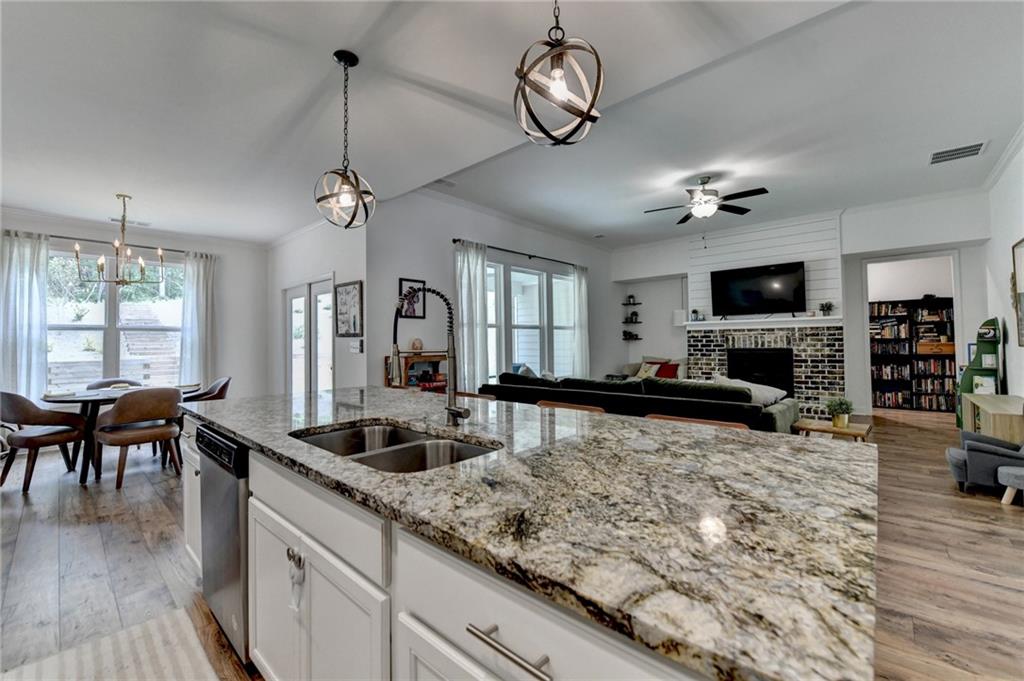 2129 Charmond Drive Monroe, GA 30656 - Photo 11 of 37 a kitchen with a stove a center island a dining table and chairs with wooden floor