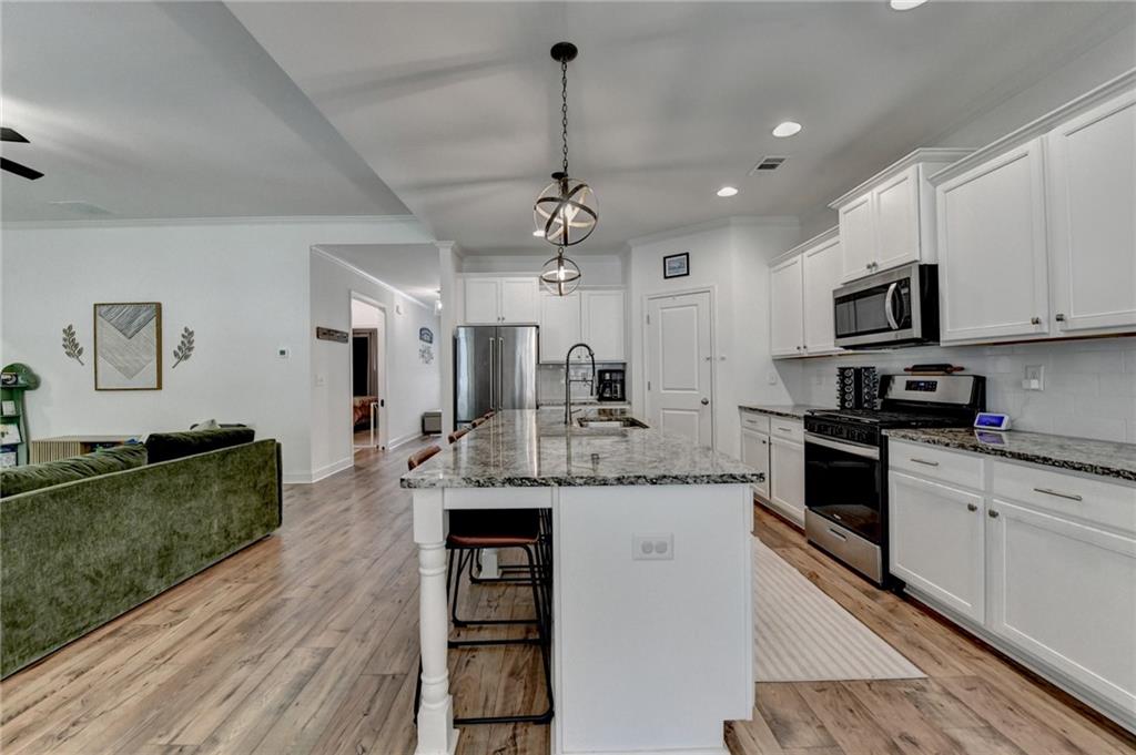 2129 Charmond Drive Monroe, GA 30656 - Photo 8 of 37 a kitchen with stainless steel appliances kitchen island granite countertop a large stove a sink dishwasher and a microwave oven with cabinets