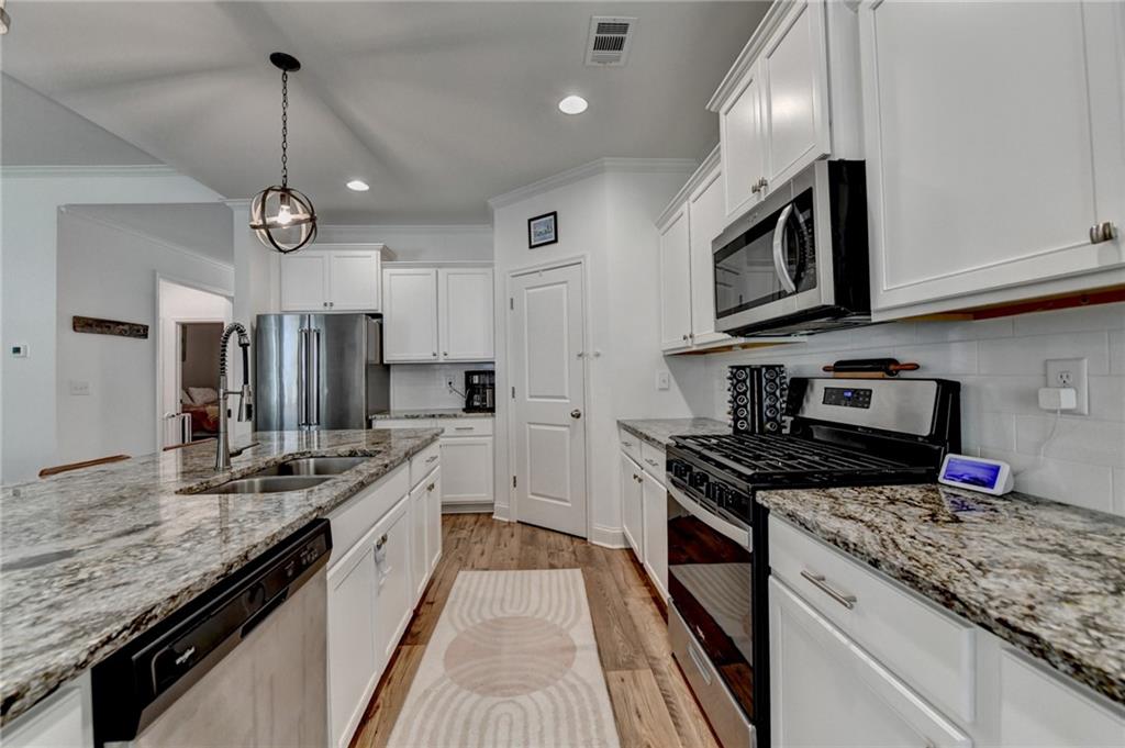 2129 Charmond Drive Monroe, GA 30656 - Photo 9 of 37 a kitchen with stainless steel appliances granite countertop a sink a stove top oven a counter space and cabinets