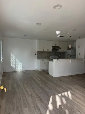 a view of a kitchen with a sink cabinets and wooden floor