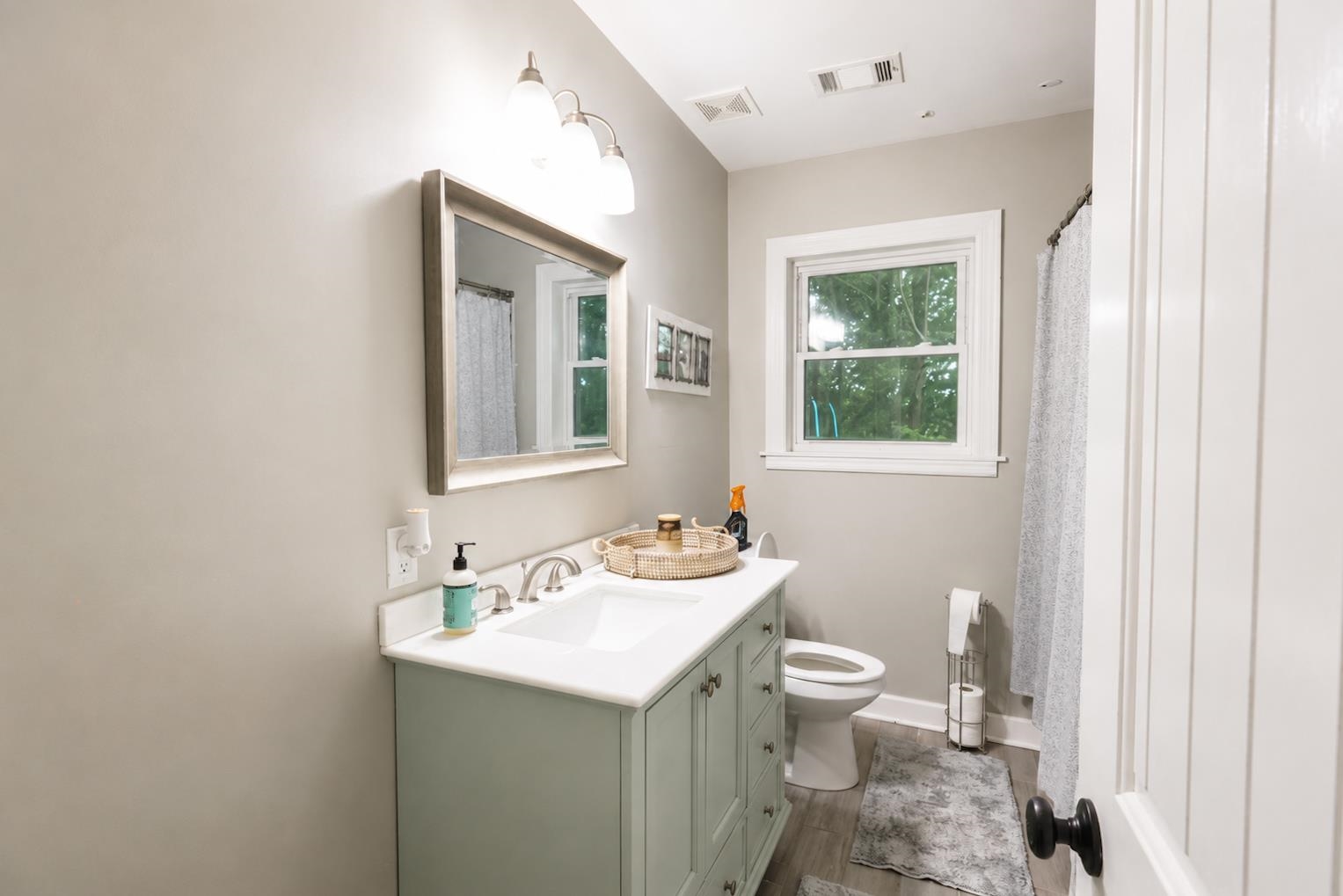 10093 Mt Carmel Road Brighton, TN 38011 - Photo 31 of 36 Bathroom featuring a light green vanity with white countertop, an undermount sink, and a framed wall mirror