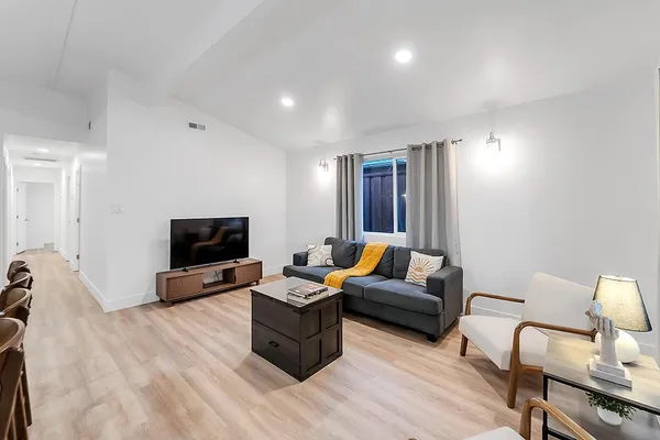 a kitchen with granite countertop a table chairs refrigerator and microwave