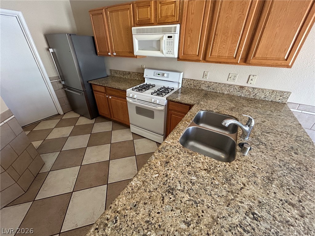 2806 Rungsted Street Las Vegas, NV 89142 - Photo 8 of 18 A well-appointed kitchen showcasing a double basin sink and checkerboard tiled flooring.