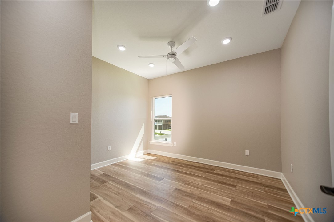 74 Whooping Crane Street Port O'Connor, TX 77982 - Photo 14 of 43 wooden floor in an empty room with a window