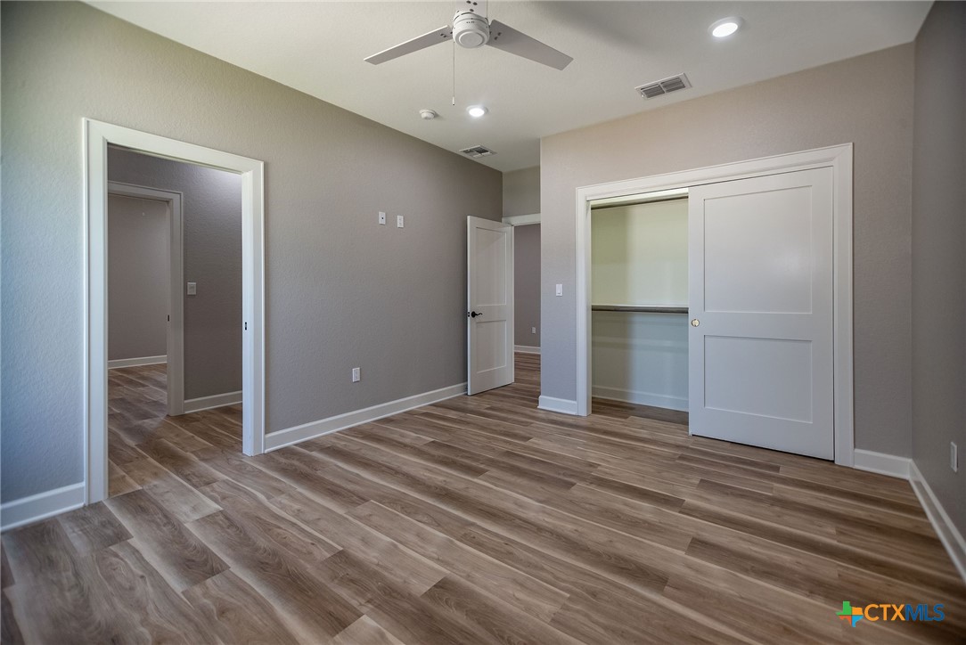 74 Whooping Crane Street Port O'Connor, TX 77982 - Photo 27 of 43 an empty room with wooden floor and way to kitchen