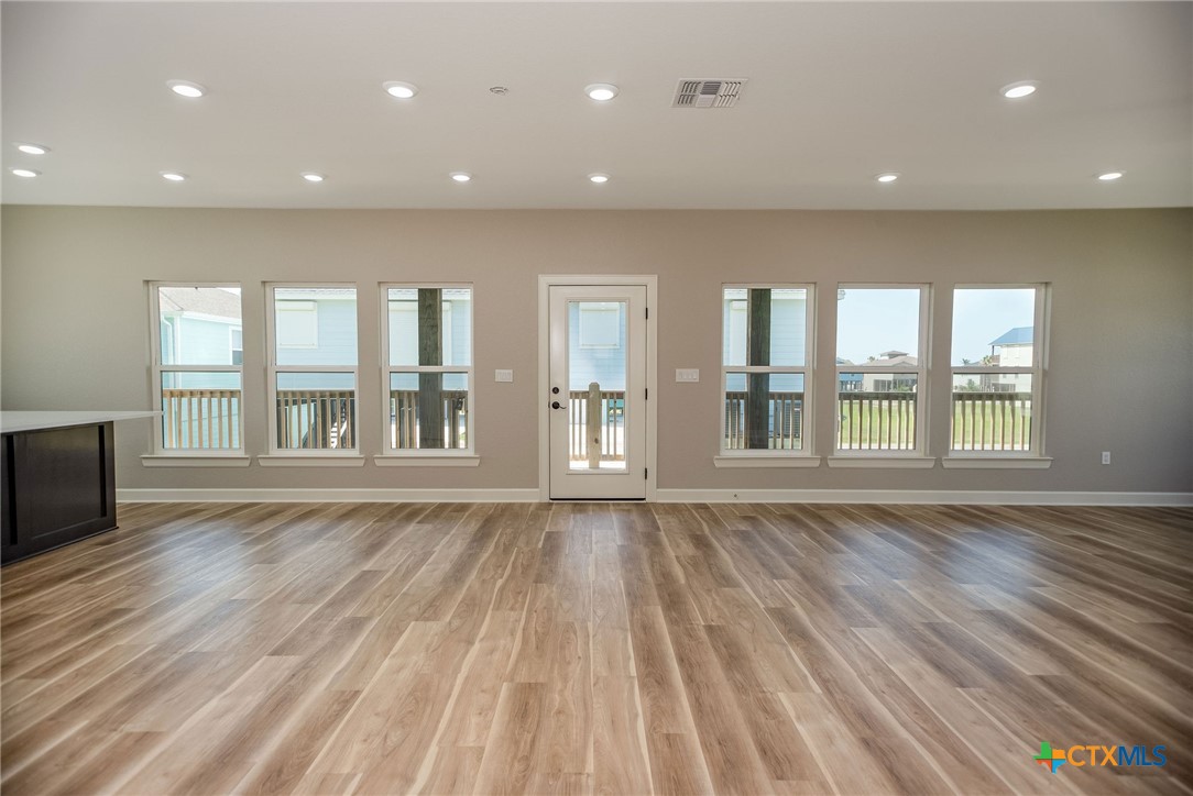 74 Whooping Crane Street Port O'Connor, TX 77982 - Photo 5 of 43 an empty room with wooden floor and windows