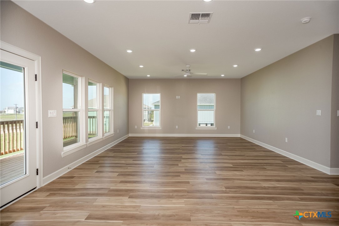 74 Whooping Crane Street Port O'Connor, TX 77982 - Photo 6 of 43 a view of an empty room with wooden floor and a window