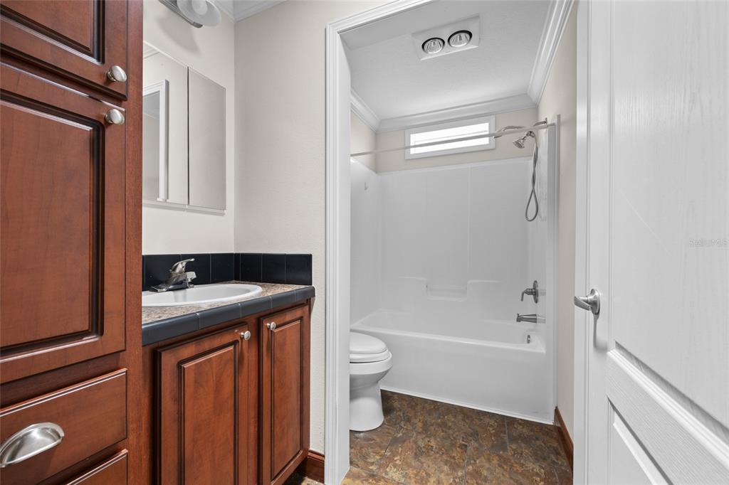 240 Swan Lake Road Melrose, FL 32666 - Photo 15 of 44 a bathroom with a granite countertop sink toilet and shower
