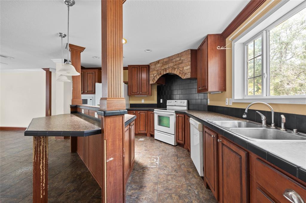 240 Swan Lake Road Melrose, FL 32666 - Photo 5 of 44 a kitchen with stainless steel appliances kitchen island granite countertop a sink and cabinets