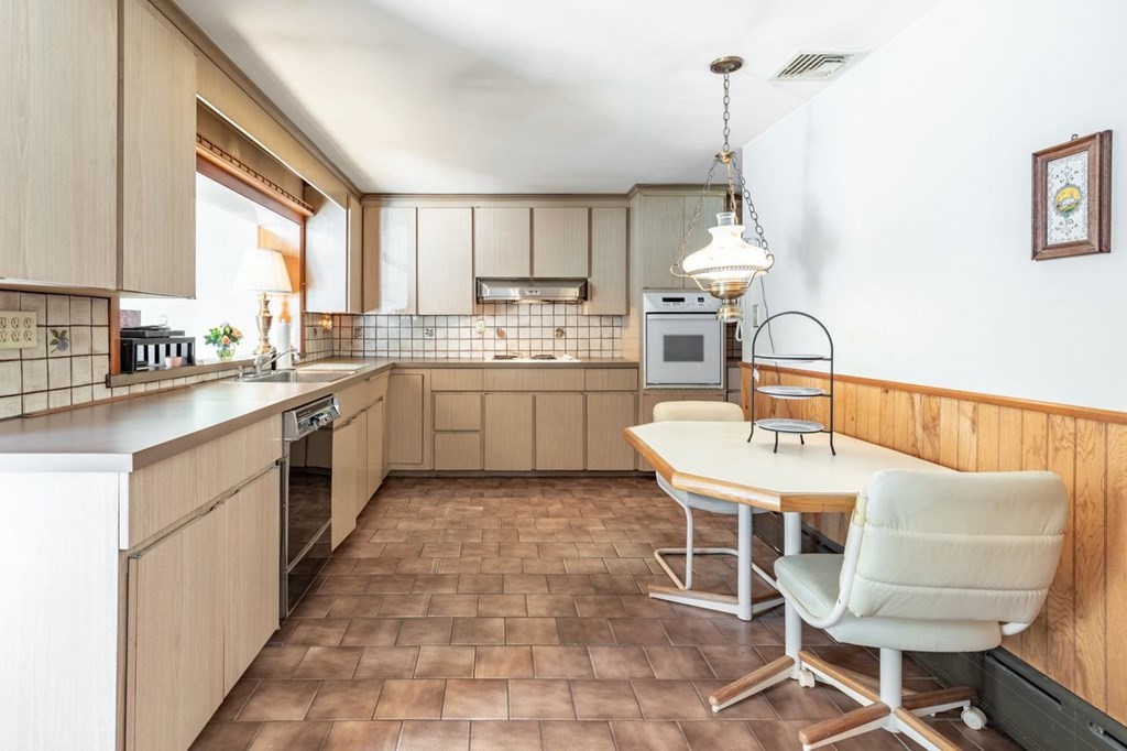 524 South Border Road Winchester, MA 01890 - Photo 8 of 24 a kitchen with a sink dining table and chairs