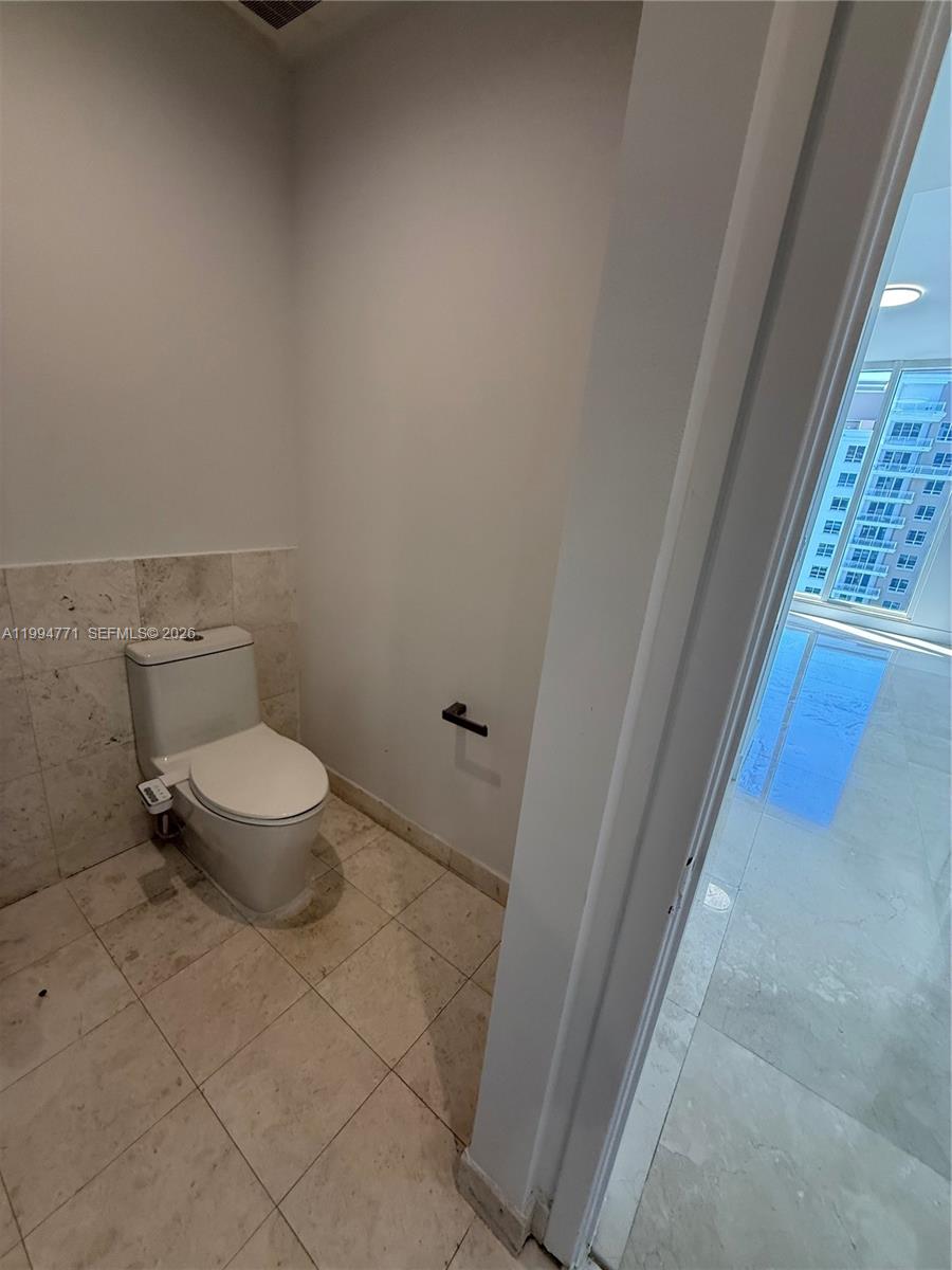 901 Brickell Key Boulevard, Unit 3102 Miami, FL 33131 - Photo 12 of 56 a white toilet sitting next to a window
