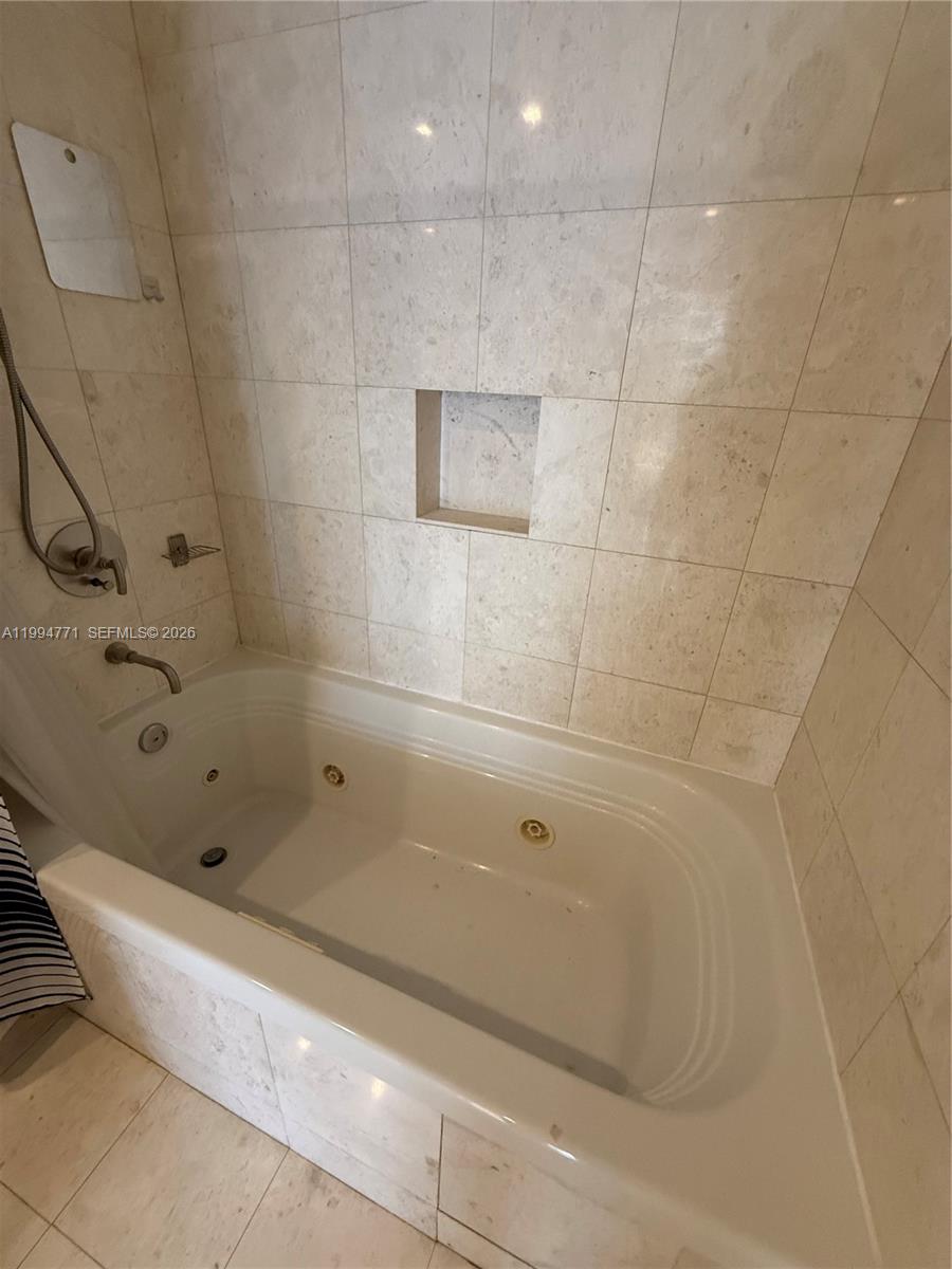 901 Brickell Key Boulevard, Unit 3102 Miami, FL 33131 - Photo 13 of 56 a bathroom with a bathtub and shower