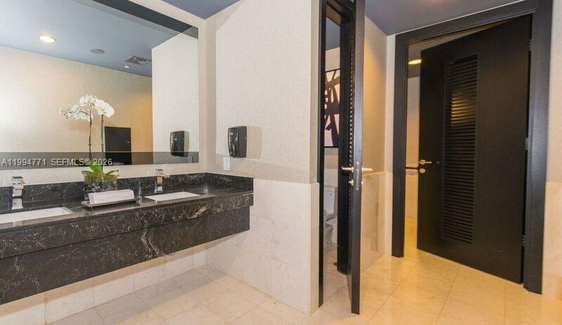 901 Brickell Key Boulevard, Unit 3102 Miami, FL 33131 - Photo 48 of 56 a large bathroom with a double vanity sink and mirror