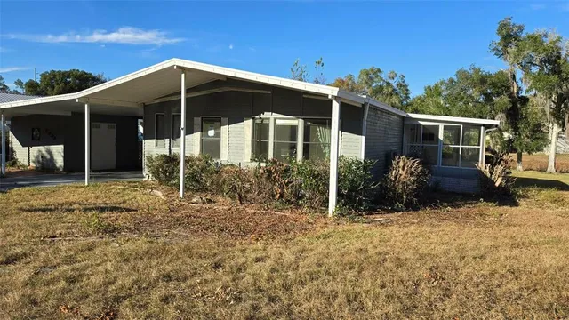 a view of a house with backyard and sitting area
