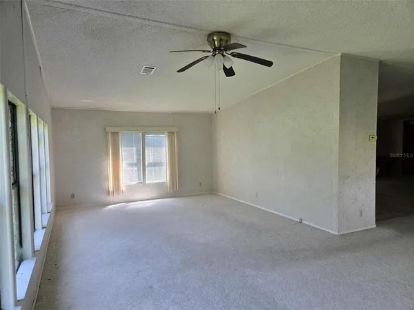 a view of a livingroom with a ceiling fan and window