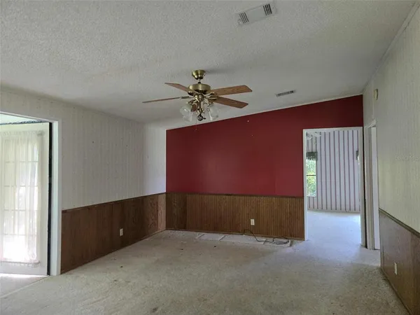 an empty room with chandelier fan