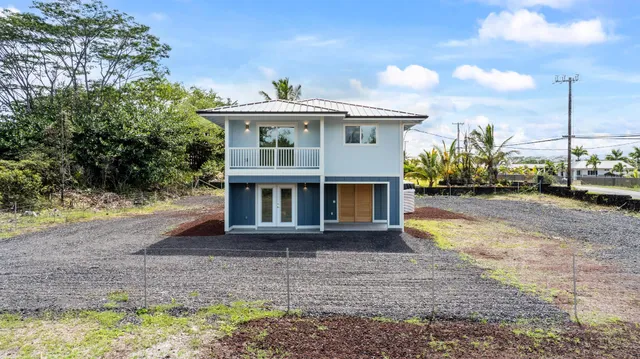 a front view of a house with a yard and trees