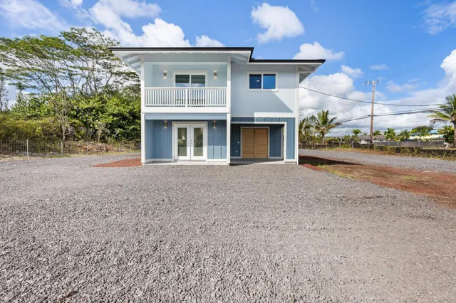 a view of a house with a patio and a yard