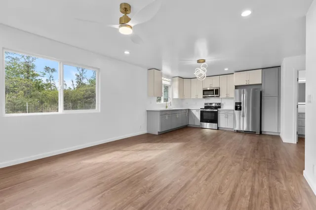a view of kitchen with wooden floor electronic appliances and window