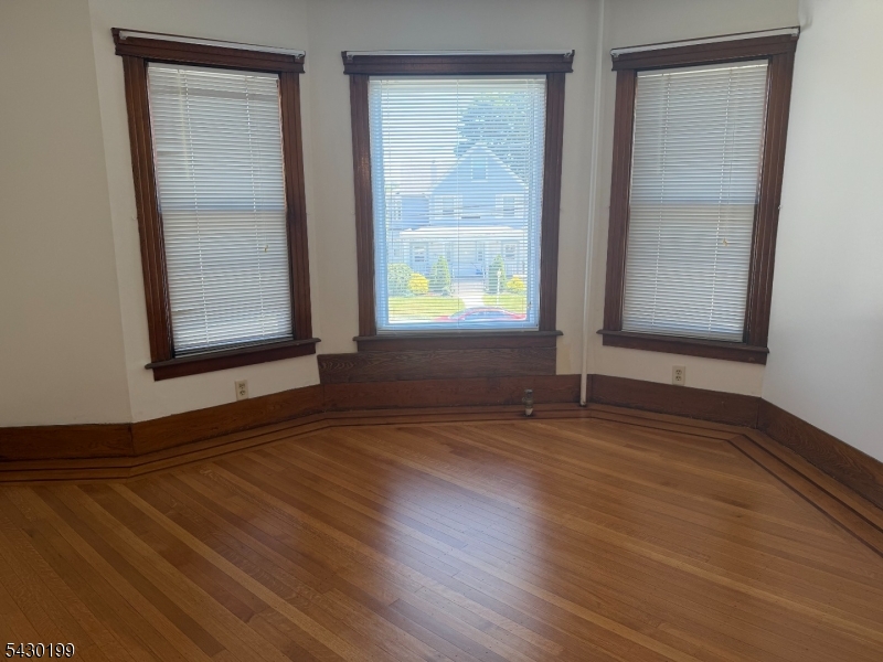 72 Baldwin Place, Unit 2 Bloomfield, NJ 07003 - Photo 9 of 24 an empty room with wooden floor and windows