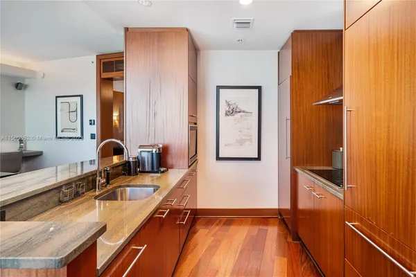 a kitchen with granite countertop a refrigerator and a sink