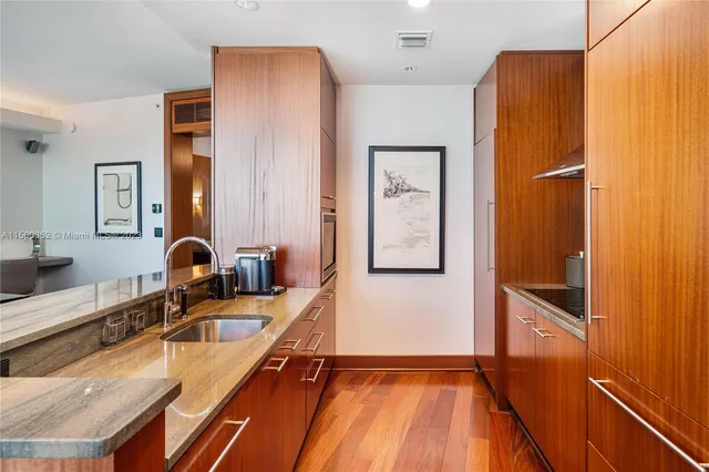 a kitchen with granite countertop a refrigerator and a sink