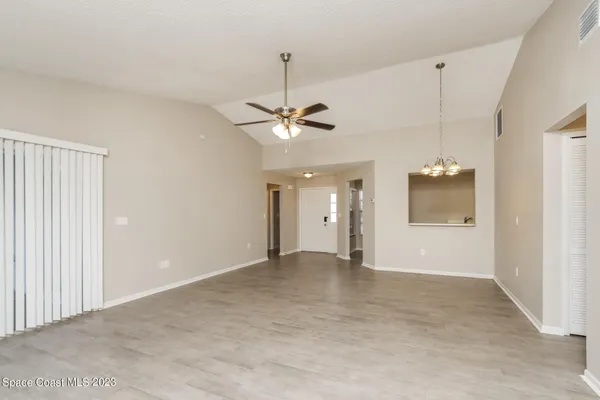 an empty room with a ceiling fan and a window
