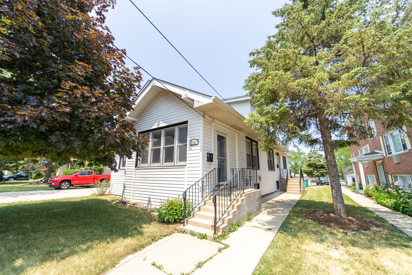 a yellow house with trees in front of it
