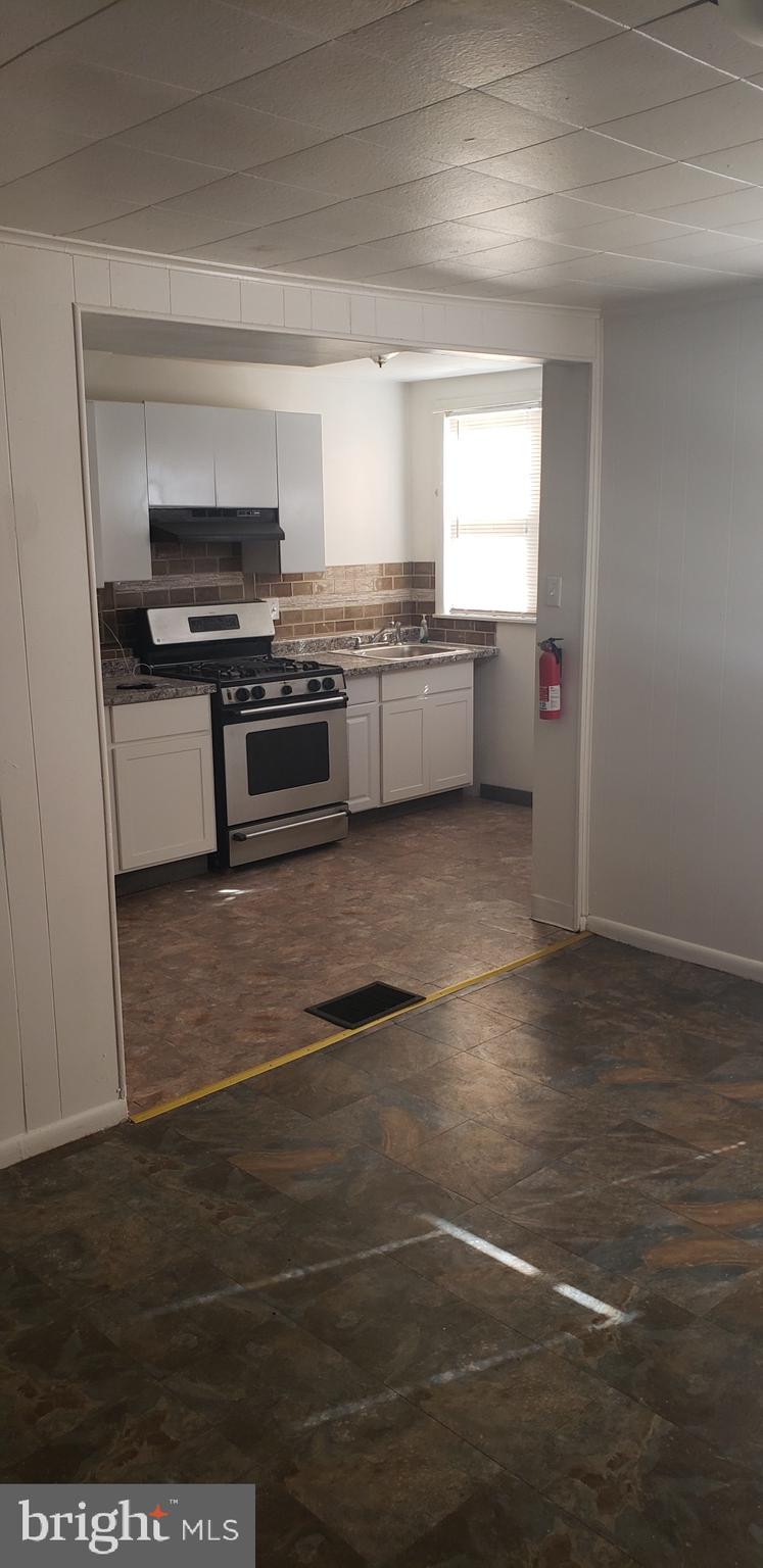 3054 Alabama Road Camden, NJ 08104 - Photo 7 of 25 a kitchen with stainless steel appliances a stove and a refrigerator