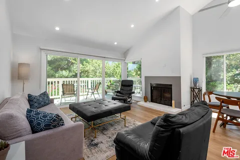 a living room with furniture fireplace and a large window