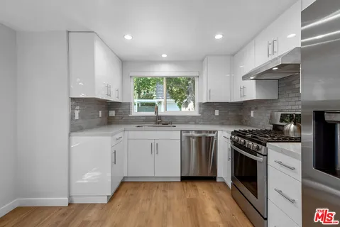 a kitchen with stainless steel appliances granite countertop a stove a sink and a microwave