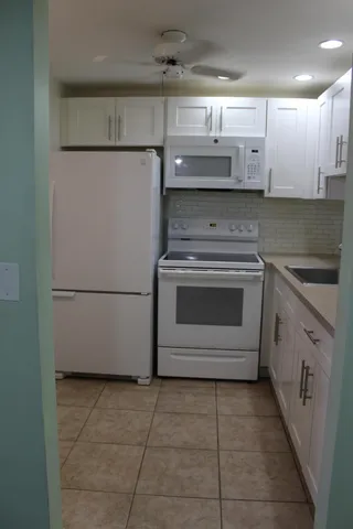 a kitchen with a stove top oven and cabinets