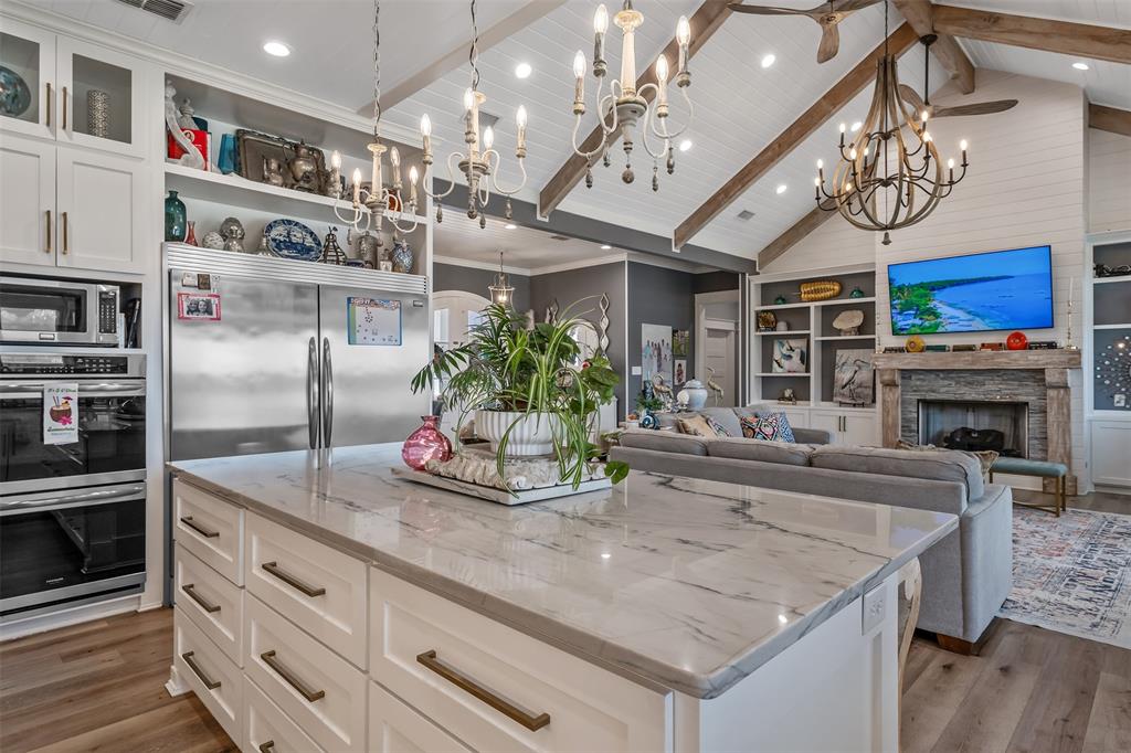16241 Big Oak Bay Road Tyler, TX 75707 - Photo 12 of 40 Expansive kitchen island with a stone-finish countertop, white cabinetry, and bronze-tone hardware