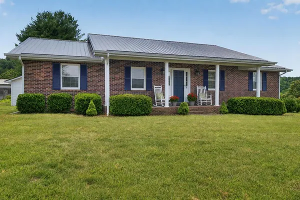 front view of a brick house with a yard