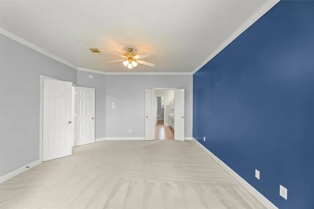 a view of an empty room with a chandelier fan