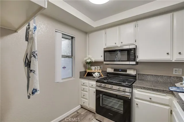 a kitchen with white cabinets and appliances