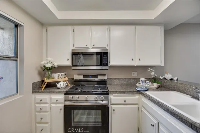 a kitchen with microwave a stove and cabinets