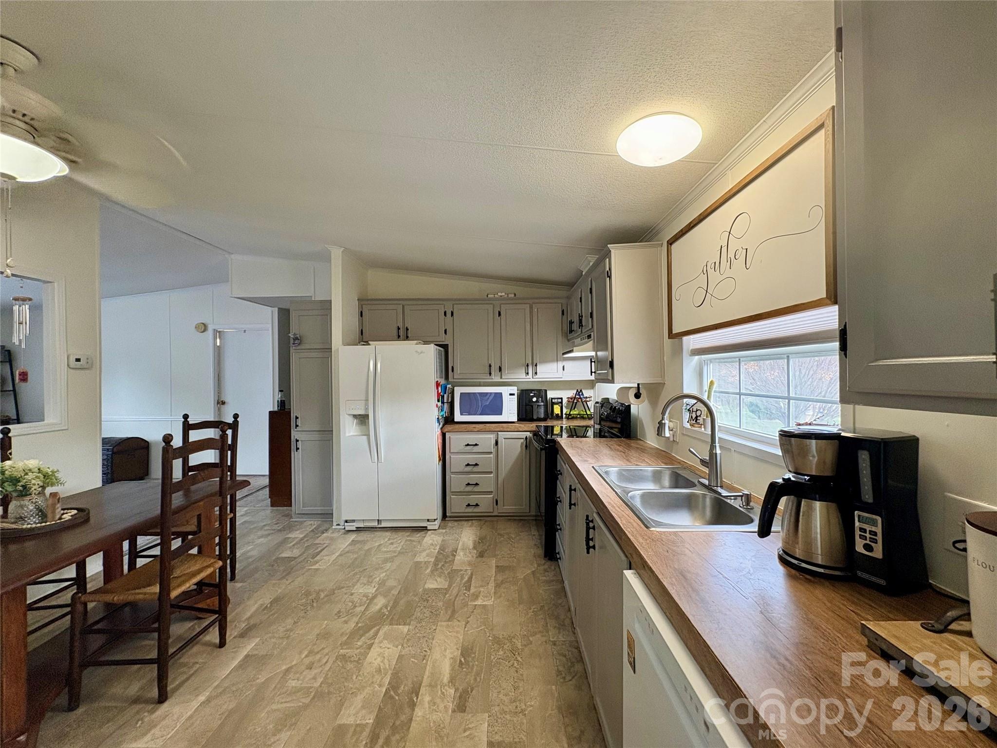 3422 Edwards Road Wingate, NC 28174 - Photo 15 of 31 a kitchen with a refrigerator a stove and a dining table with wooden floor
