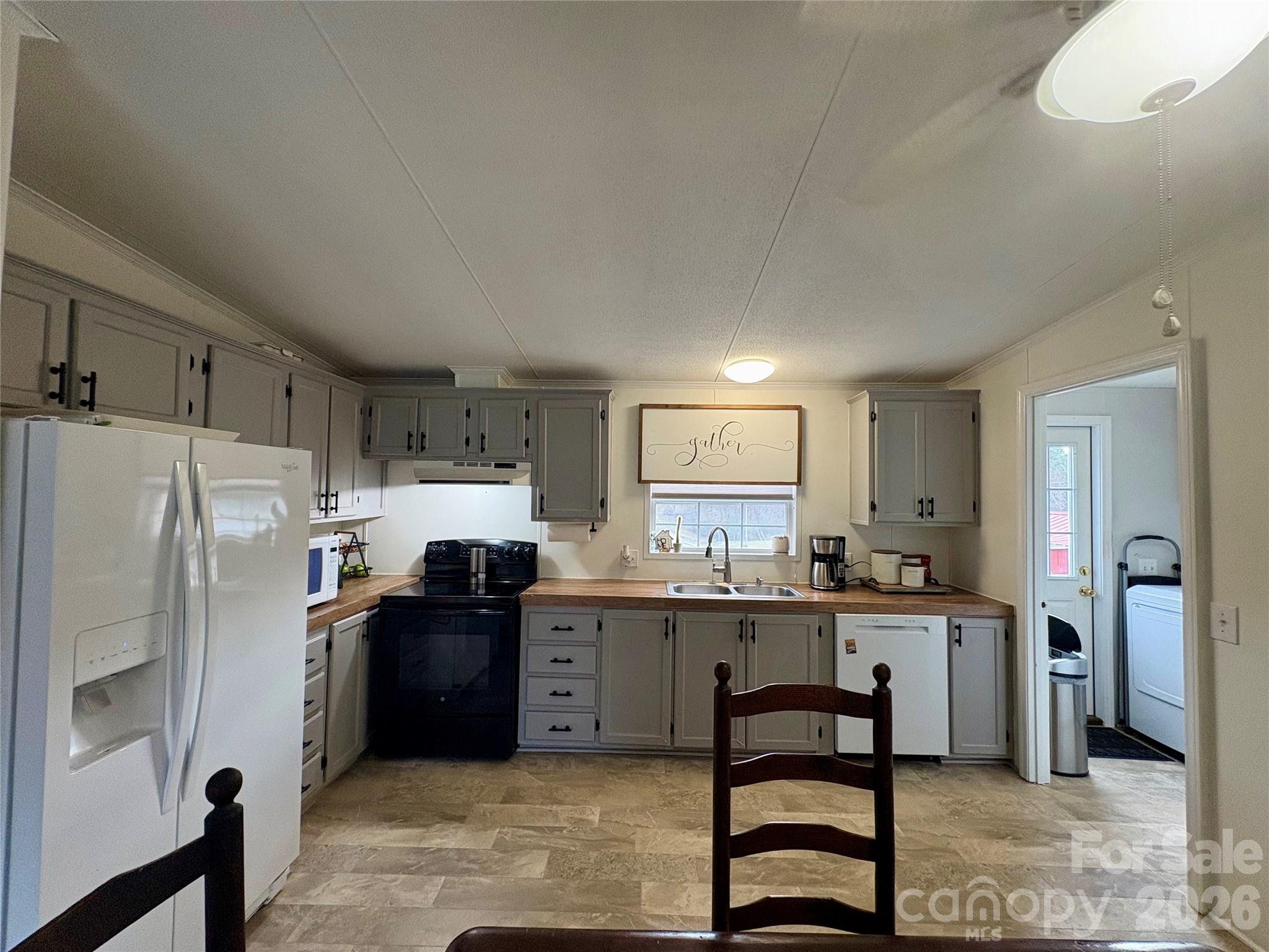 3422 Edwards Road Wingate, NC 28174 - Photo 19 of 31 a kitchen with stainless steel appliances a sink a stove a refrigerator cabinets and dining table