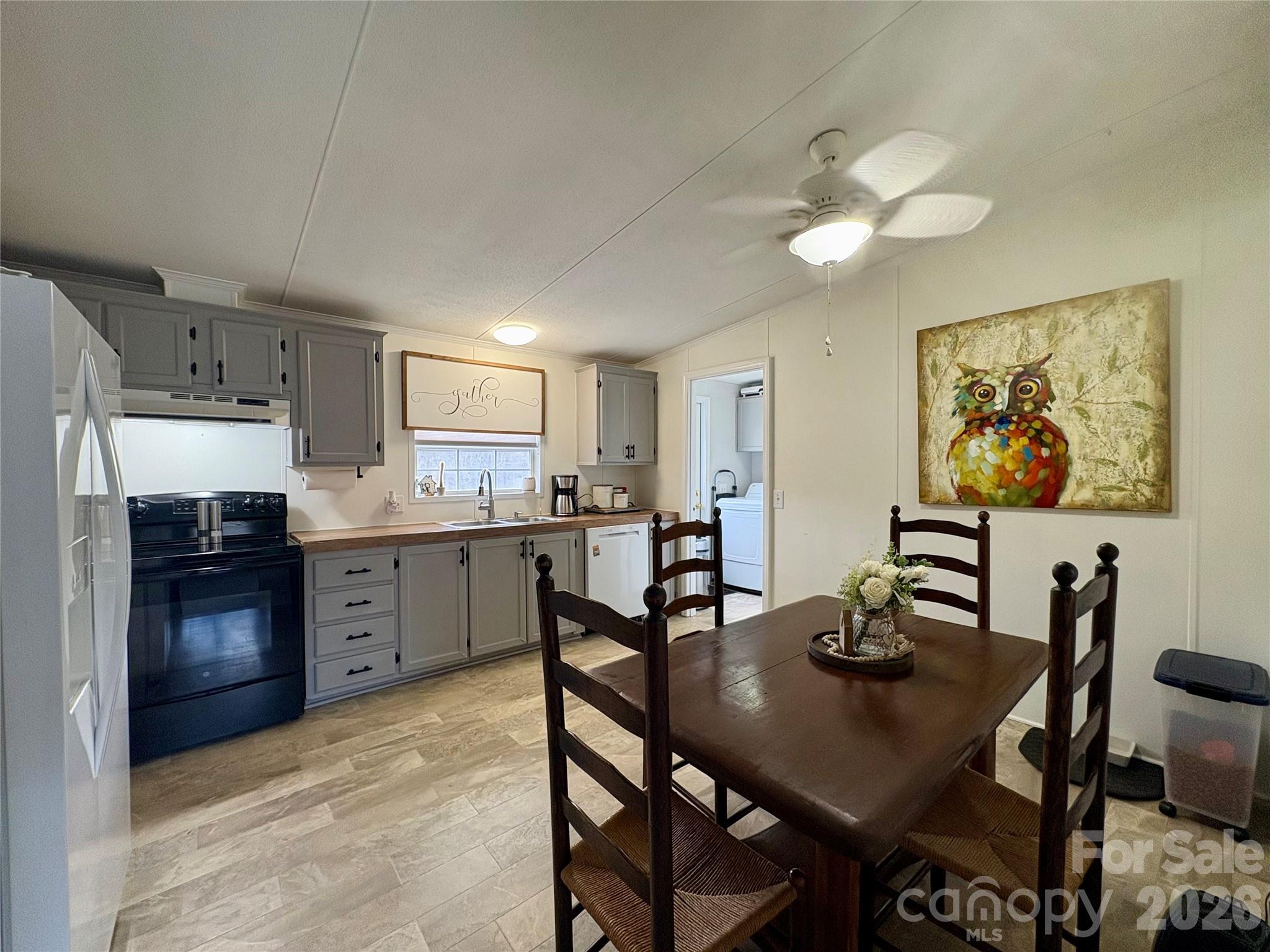3422 Edwards Road Wingate, NC 28174 - Photo 21 of 31 a open dining room with stainless steel appliances kitchen island granite countertop a table chairs and a refrigerator